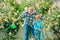 Grandfather and grandchild enjoying in the garden with roses flowers. Grandfather talking to grandson. Spring and summer