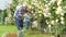 Grandfather and grandchild. Professional Gardener at Work. Flower care and watering. Concept of a retirement age. Father