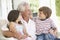 Grandfather And Grandchildren Relaxing In Chair