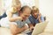 Grandfather And Grandchildren Using Laptop At Home