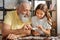 Grandfather and granddaughter connecting two jigsaw puzzle pieces