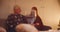 Grandfather granddaughter ginger girl daughter sitting on sofa christmas gift give comfort family dinner evening