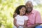 Grandfather and granddaughter outdoors smiling