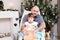 Grandfather and granddaughter portrait in Christmas interior. Little girl sitting behind older father with Teddy bear