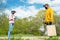 Grandfather and granddaughter stand at distance on road