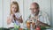 Grandfather with granddaughter tastes smoothies