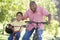 Grandfather and grandson on bikes outdoors smiling