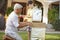 Grandfather And Grandson Building Model Robot In Garden