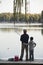 Grandfather and grandson fishing off of dock at lake