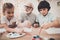 Grandfather, grandson and granddaughter at home. Children are painting.