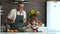 Grandfather and grandson in the kitchen. An elderly man gives the boy a kitchen knife and teaches you how to cut a