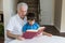 Grandfather and grandson read a book sitting at a white table