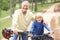 Grandfather and grandson riding bicycle in park