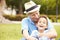 Grandfather And Grandson Sitting In Park Together