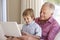 Grandfather And Grandson Using Laptop At Home