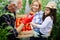 Grandfather growing organic vegetables with grandchildren and family at farm