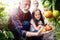 Grandfather growing organic vegetables with grandchildren and family at farm