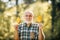 Grandfather having fun in autumn park. Freedom retirement concept. Portrait of a senior autumn man outdoors. Maple leaf