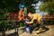 Grandfather helping grandson to put on roller skates in urban park