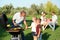 Grandfather with little kids cooking food on barbecue grill and their family