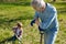Grandfather looking at child scooping ground