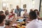 Grandfather making a toast standing at the dinner table celebrating with his family, close up