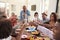 Grandfather making a toast standing at the dinner table celebrating with his family,close up