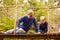 Grandfather playing with grandson on a bridge in a forest