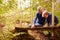 Grandfather playing with grandson on a bridge in a forest