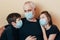 Grandfather in a protective mask hugs grandchildren advises not to panic and tells the rules of conduct during quarantine introduc