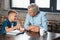 grandfather reading book with grandson showing thumb up