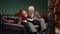 Grandfather reads a fairy tale to his grandson before bedtime. Elegant gray haired man with a little boy is sitting on a