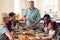 Grandfather Serving As Multi-Generation Family Celebrating Thanksgiving At Home Eating Meal Together