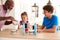 Grandfather Serving Ice Cream To Grandchildren In Kitchen