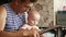 Grandfather is showing to his toddler grandson a vintage acoustic guitar and the boy curiously looks on it and touches