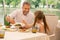 Grandfather smiling enjoying breakfast with his girl