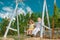 Grandfather and son swinging in garden. Granddad and grandchild playing on swing.