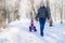 Grandfather takes his granddaughter on a sled through a snow-covered Park. Active family holidays for adults and children. A man