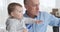 Grandfather talking with baby granddaughter at home