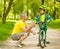 Grandfather talking with his grandson riding a bicycle and showing thumbs up