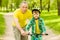 Grandfather teaches his grandson to ride a bike