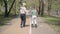 Grandfather teaches his grandson to roller skate in the park. Leisure outdoors. Grandfather and grandson spending time