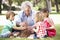 Grandfather Teaching Grandchildren To Build Camp Fire