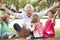 Grandfather Teaching Grandchildren To Build Camp Fire