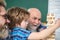 Grandfather teaching grandson how to play Jenga games. Grandfather father and son having fun together. Man family