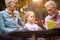 Grandfather telling story to his granddaughter, holding paper boat