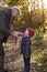 Grandfather Tying Granddaughter`s Scarf On Autumn Walk