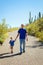 Grandfather and Young Grandson Hike Downhill, Holding Hands on a