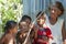 Grandma Amazonia, indigene grandmother with four grandchildren playing with bow.and arrow