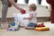 Grandma and baby with toys on the floor in livingroom